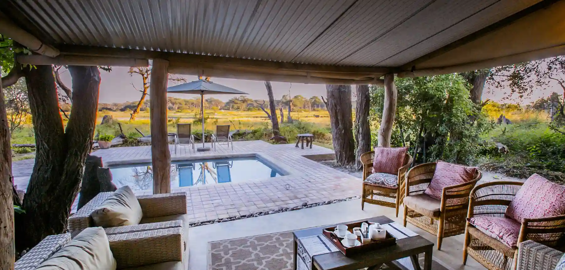 Covered safari lodge patio with plunge pool and open grassland view