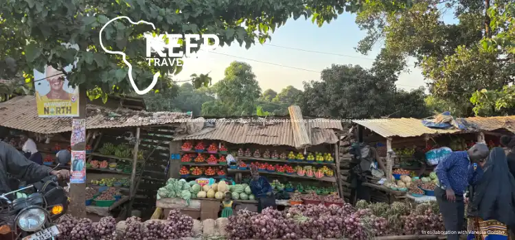 Outdoor-market-scene-with-stalls-displaying-fresh-vegetables-and-fruits-including-onions-cabbages-and-tomatoes-with-people-browsing-in-front-of-the-stands