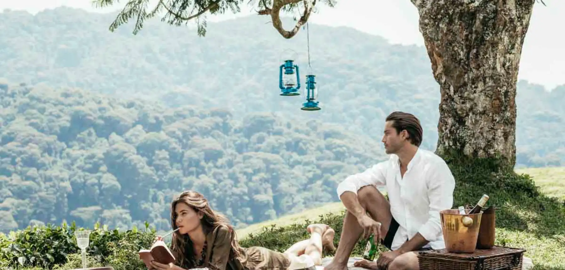 Couple relaxing on a picnic blanket with mountain forest views