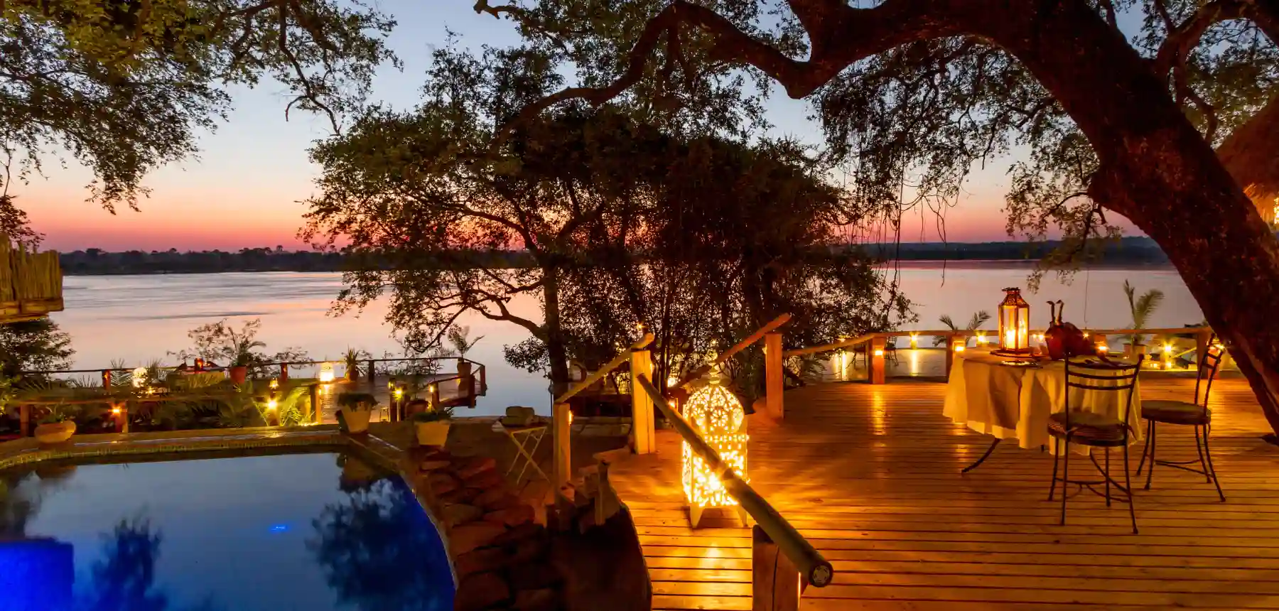 Luxury riverside lodge deck with pool and sunset views in Africa