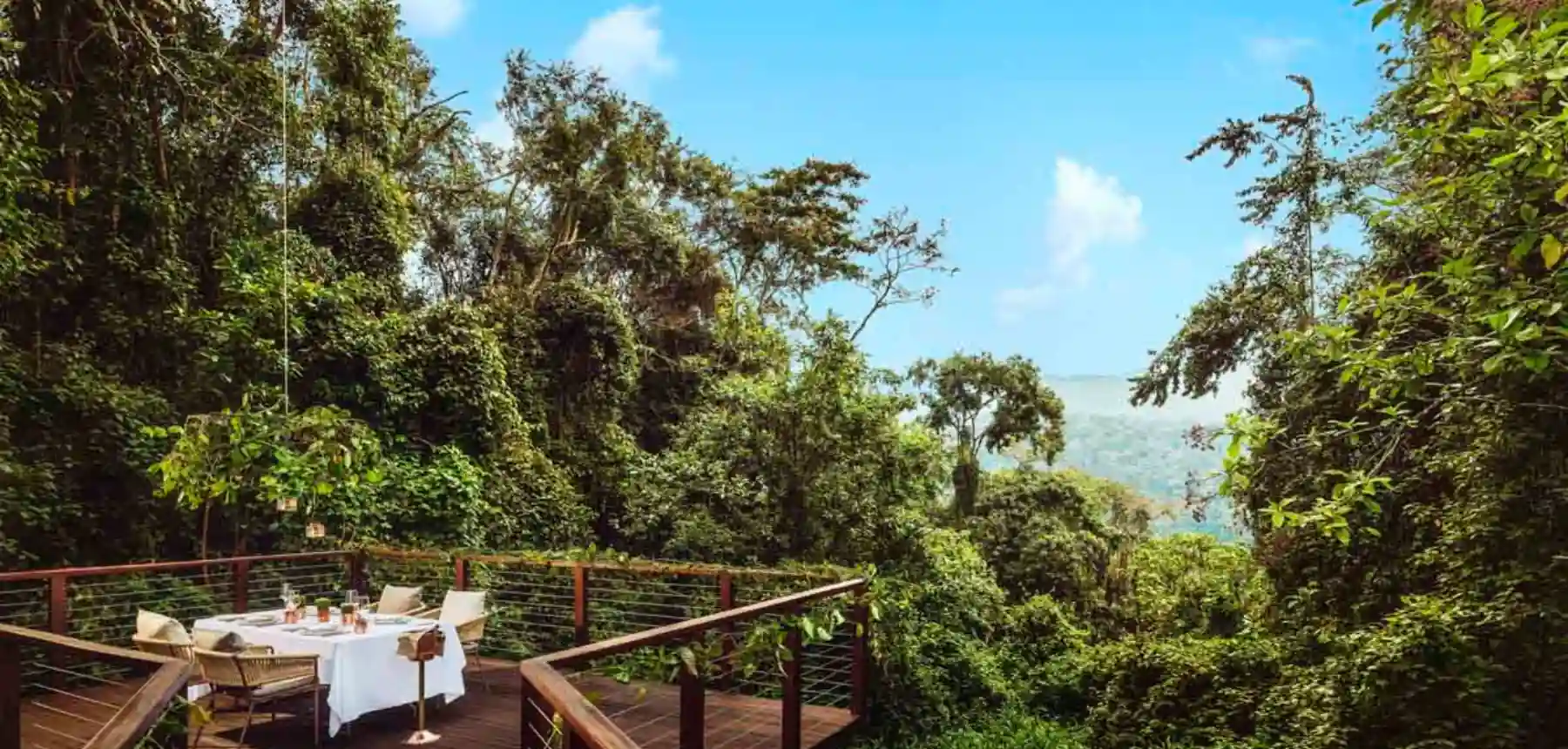 Private dining deck surrounded by tropical forest with distant mountain views