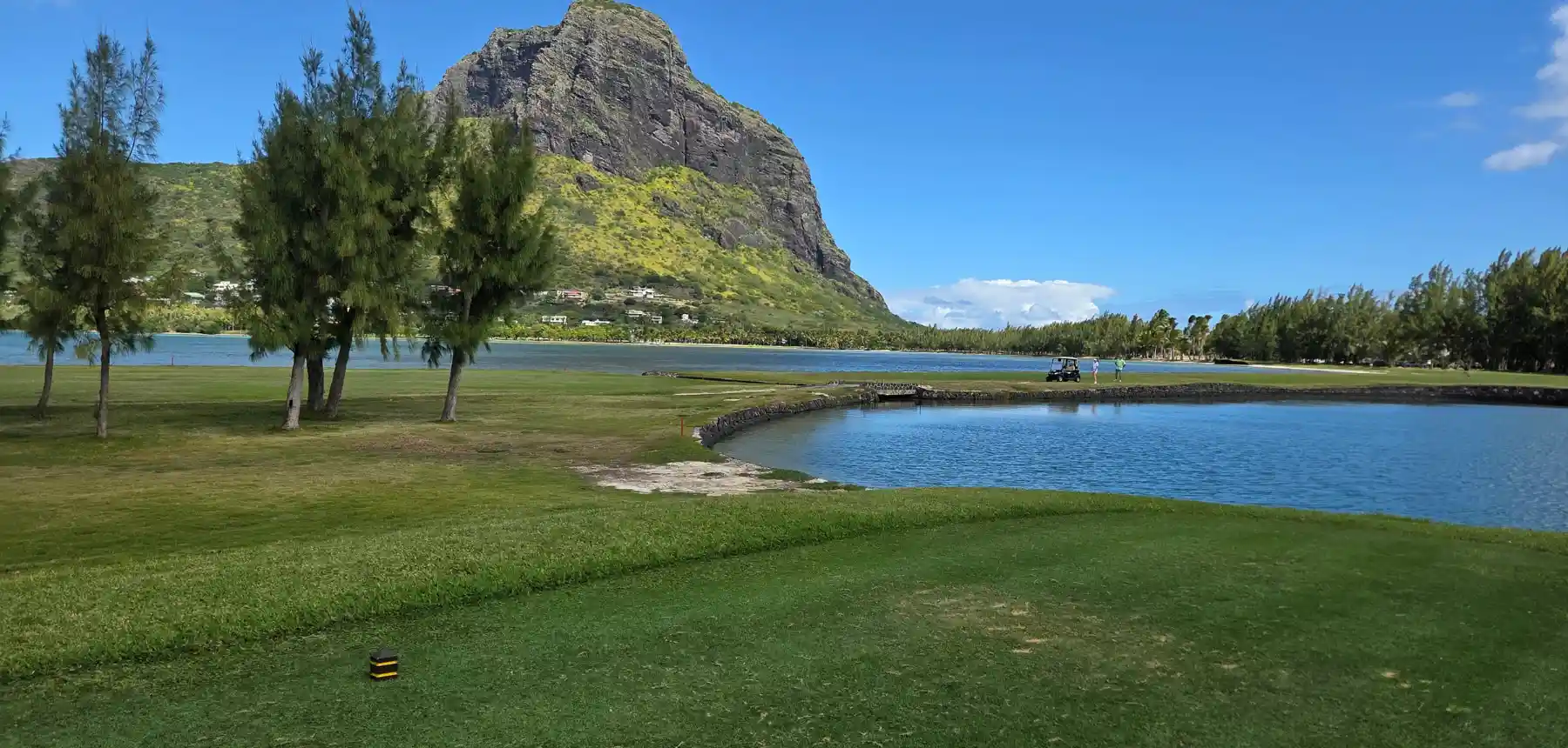 Scenic coastal golf course with lagoon and mountain views in a tropical destination