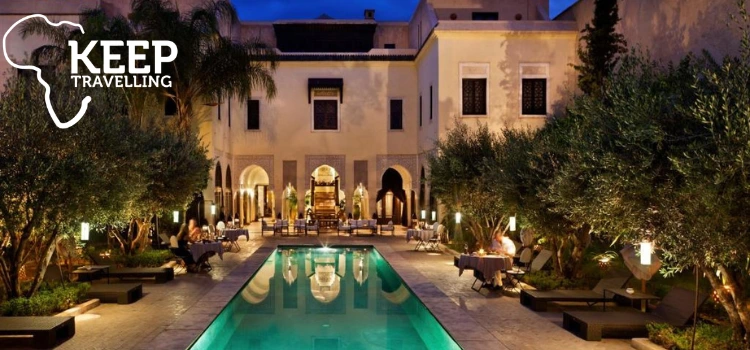 Luxury Moroccan riad courtyard with pool and evening lights
