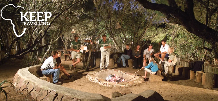 Guests gathered around an outdoor boma fire during a safari experience at Kariega Game Reserve